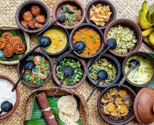 a table topped with bowls of different types of food at Pride Rock Villa & Tree House in Sigiriya