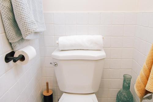a white bathroom with a toilet with a towel on it at B Hotel in Toronto