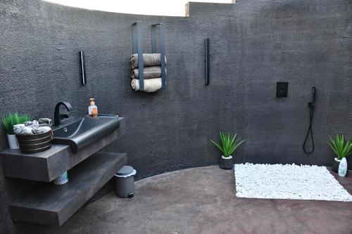 a bathroom with a sink and a black wall at House California 