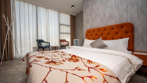 a bedroom with a large bed with an orange headboard at Amgun Hotel Ulaanbaatar in Ulaanbaatar