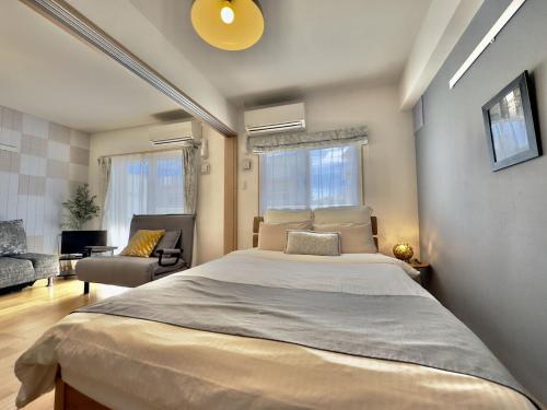 a bedroom with a large bed and a living room at Luana Lea Karate Kaikan Mae in Tomigusuku