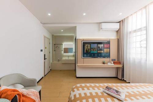 a room with a bed and a television and a bathroom at 尚品9号海景民宿Seaview Hotel in Xiamen