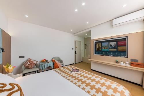 a bedroom with a large bed and a flat screen tv at 尚品9号海景民宿Seaview Hotel in Xiamen