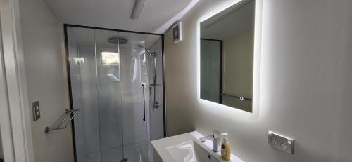 a bathroom with a shower and a sink and a mirror at Rest and Recharge Retreat 1-2 Guests in Ashburton