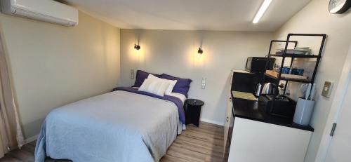 a small bedroom with a bed and a refrigerator at Rest and Recharge Retreat 1-2 Guests in Ashburton