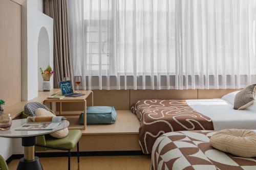 a hotel room with two beds and a table at 尚品9号海景民宿Seaview Hotel in Xiamen