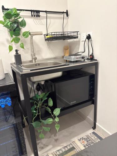 a kitchen counter with a sink and a microwave at شقه فاخره بأثاث مريح غرفة نوم وصاله in Jeddah