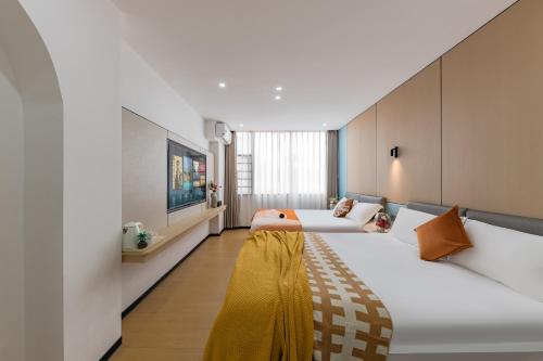 a hotel room with two beds and a tv at 尚品9号海景民宿Seaview Hotel in Xiamen