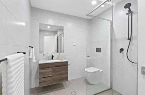 a bathroom with a shower and a toilet and a sink at Cozy Stay Near CBD Free Wi-Fi, Netflix & Parking in Beecroft
