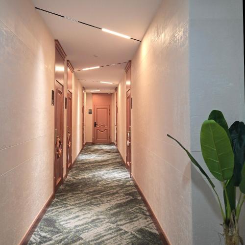 a hallway with a pink door and a plant at Amgun Hotel Ulaanbaatar in Ulaanbaatar