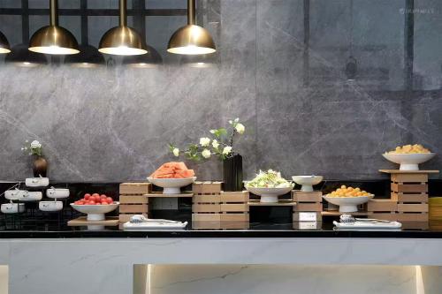 a buffet with bowls of food on a counter at YANG TRAVEL Hotel 重庆解放碑洪崖洞店 in Chongqing