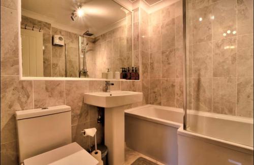 une salle de bain avec toilettes, lavabo et baignoire dans l'établissement Stylish 1 Bedroom Apartment with Free Parking and Links to London & Essex, à Stifford