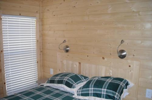 sypialnia z łóżkiem w drewnianej ścianie w obiekcie Yosemite Lakes Cottage 49 w mieście Harden Flat