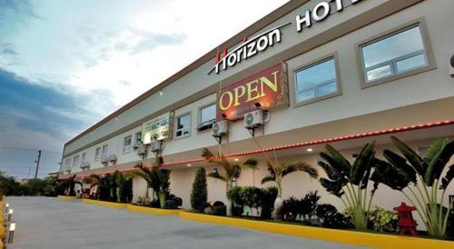 a restaurant with a sign on the side of a building at Horizon Hotel in Olongapo