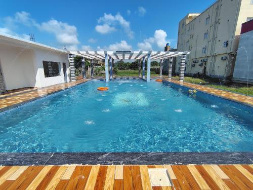 a large swimming pool with a wooden deck at Sea Smile Inn in Mandarmoni
