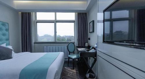a bedroom with a bed and a desk with a window at Xana Hotelle Xi'an GONG IP South Gate of Zhonglou in Xi'an