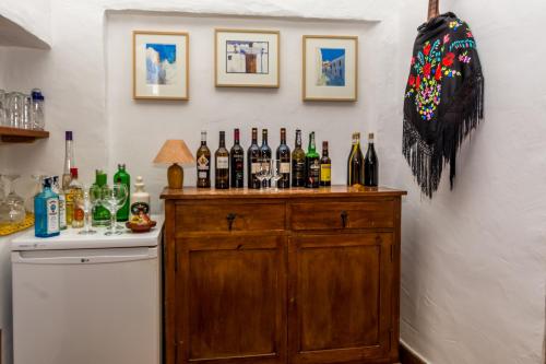 a bunch of bottles on a wooden cabinet in a kitchen at Hotel Los Castaños in Cartajima