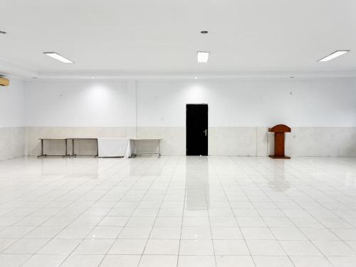 an empty room with a white floor and a black door at RedDoorz at Hotel Nuansa Indah Denpasar in Denpasar