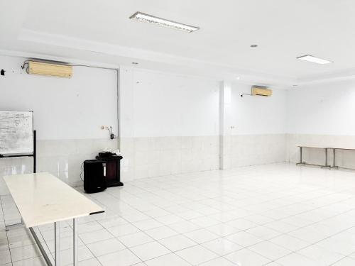 an empty room with a white floor and white tiles at RedDoorz at Hotel Nuansa Indah Denpasar in Denpasar