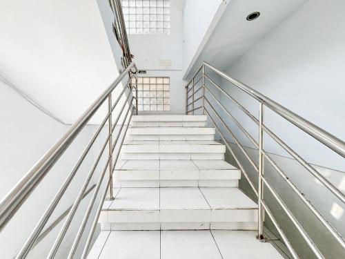 a stair case in a building with white stairs at RedDoorz at Hotel Nuansa Indah Denpasar in Denpasar