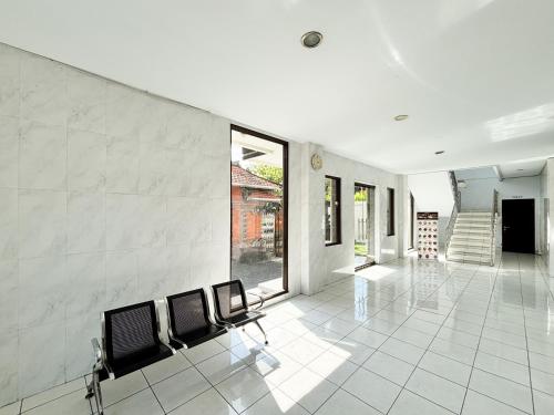 a room with chairs on a white tile floor at RedDoorz at Hotel Nuansa Indah Denpasar in Denpasar
