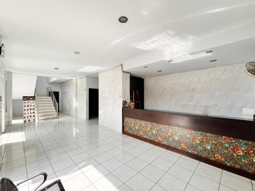 a lobby with a counter with flowers on it at RedDoorz at Hotel Nuansa Indah Denpasar in Denpasar