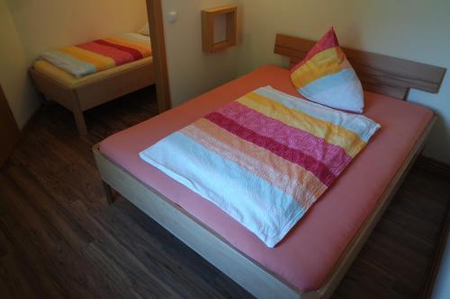 a bed with two colorful blankets and pillows on it at Ferienwohnungen "Am Mühlteich" in Radeburg