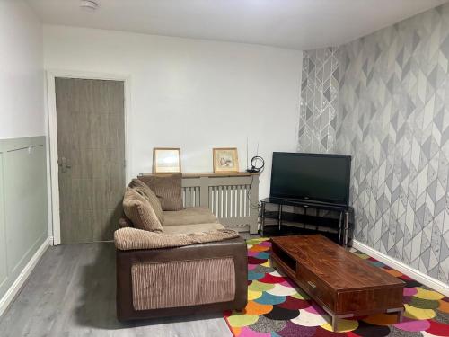 a living room with a couch and a flat screen tv at 2 bed flat in Dudley