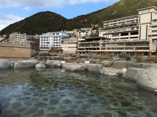 a river in a city with buildings in the background at Gerobal Hostel in Gero