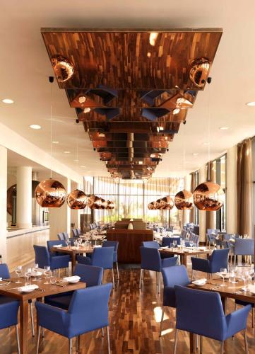 a dining room with tables and blue chairs at Radisson Blu Hotel, Abu Dhabi Yas Island in Abu Dhabi