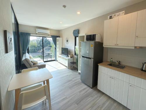 a kitchen with a refrigerator and a table and a counter at The Title Residencies Naiyang by Mill in Nai Yang Beach