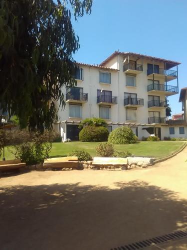 an apartment building with benches in front of it at Apartamento Playa Mar Azul in El Quisco