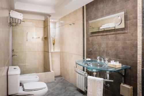 a bathroom with a sink and a toilet at Montañas Azules Apart Hotel in Mendoza