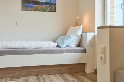 a room with a bed with two pillows on it at Kanalkajüte Wilhelm in Hanerau-Hademarschen