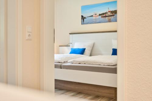 a bedroom with a bed and a painting on the wall at Kanalkajüte Wilhelm in Hanerau-Hademarschen