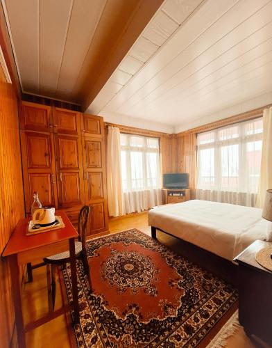 a bedroom with a bed and a desk and a table at SEWANS PLACE Homestay in Mirik