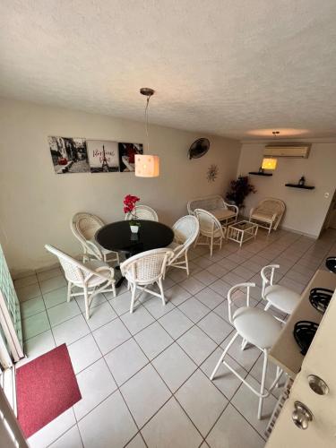 a dining room with white chairs and a table at Departamento planta baja en la laguna in Acapulco