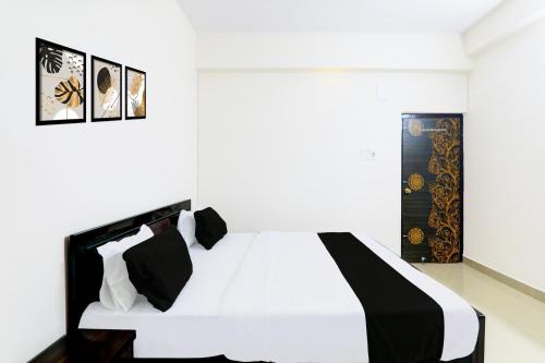 a black and white bed in a white room at Collection O Kadam Ghat Near Ashok RajPath in Patna