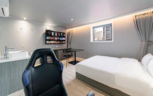 a bedroom with a white bed and a desk at Aank Hotel Incheon Bupyeong in Incheon