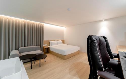 a hotel room with a bed and a chair at Aank Hotel Incheon Bupyeong in Incheon