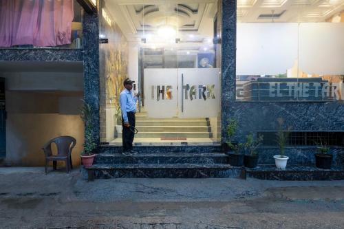 a man standing on the steps of a building at Hotel Lemon wood kalakoti in New Delhi