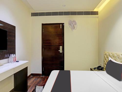Un dormitorio con una cama y una puerta de madera. en Hotel O Adarsh Nagar Metro Station Delhi Formerly Family Inn, en Nueva Delhi