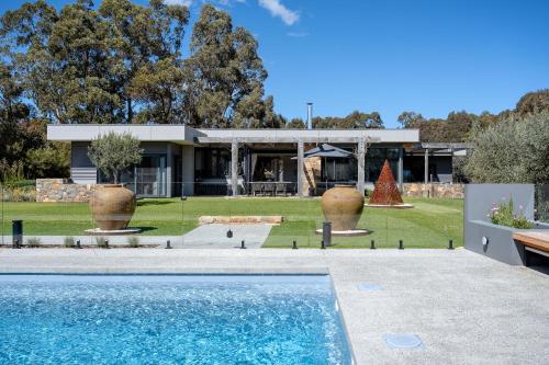 una casa con piscina frente a un patio en Ginahgulla Olive Estate I Private Properties, en Margaret River Town