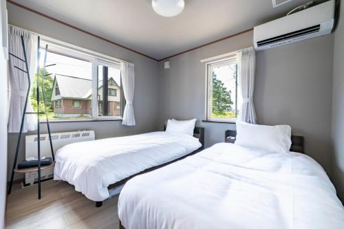 two beds in a room with two windows at Niseko Mt Village in Niseko