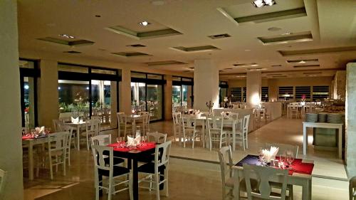 a dining room with white tables and white chairs at Ionion Star Hotel in Lefkada Town