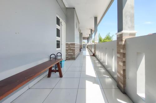 un couloir vide d'un immeuble avec un banc dans l'établissement RedDoorz at NN Guest House Exit Tol Klodran Solo, à Solo