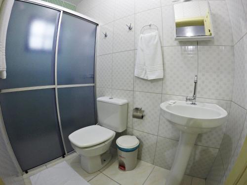 uma casa de banho com um chuveiro, um WC e um lavatório. em Pousada Justen em Gramado