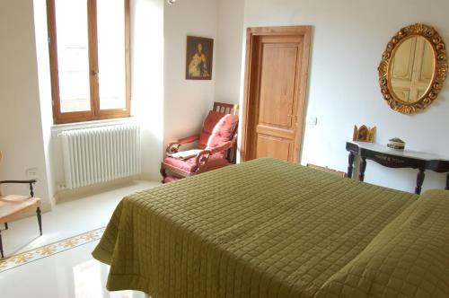 a bedroom with a bed and a chair and a mirror at Affittacamere Le Fonti in Arcidosso