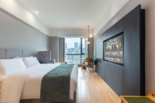 a hotel room with a bed and a tv at Chongqing From Hotel in Chongqing