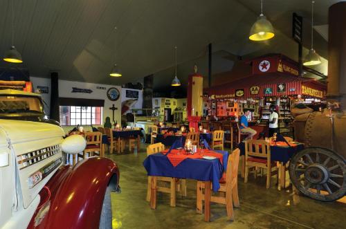 a restaurant with tables and chairs and a car in it at Gondwana Canyon Roadhouse in Stamprivier